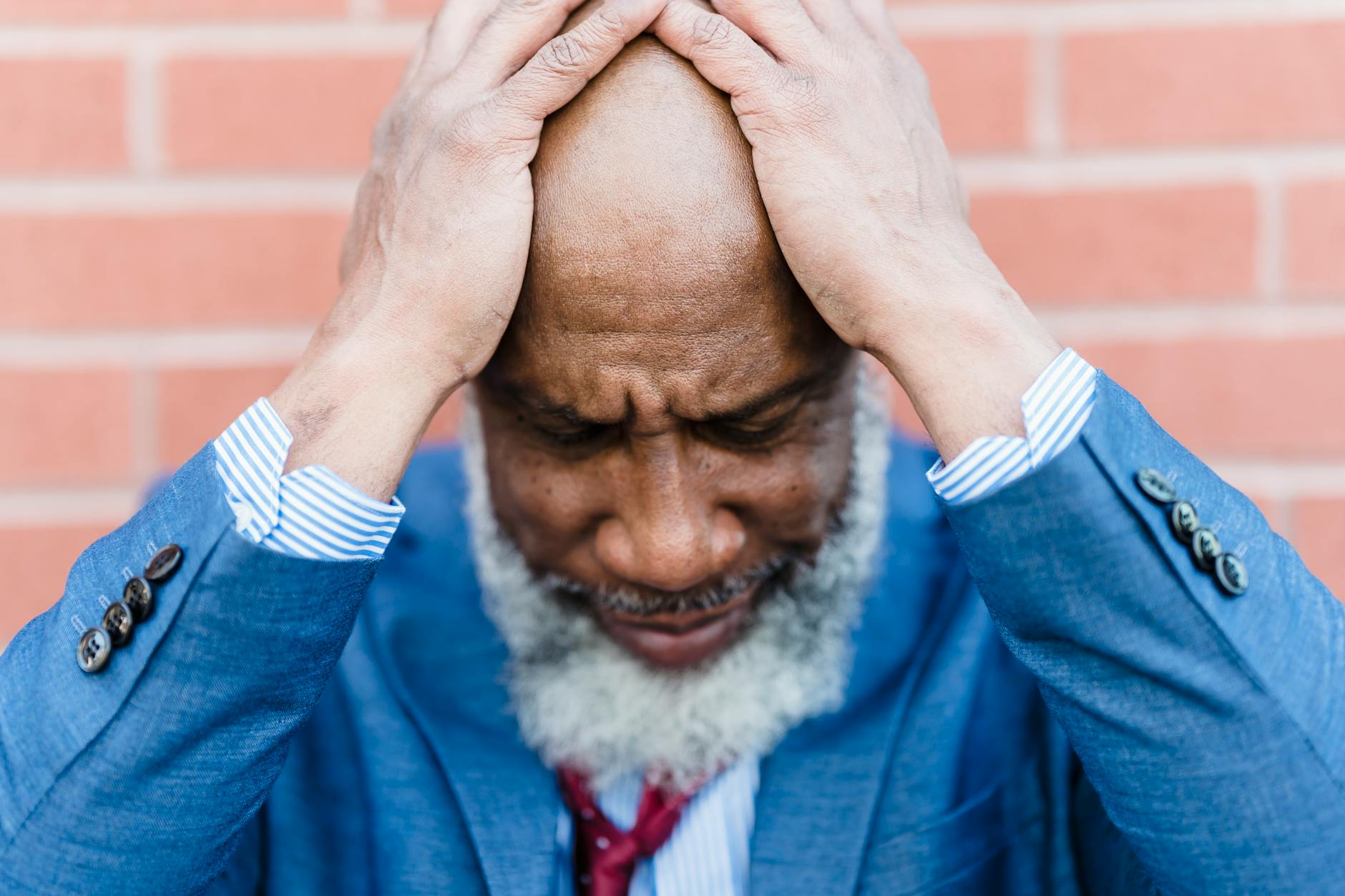 stressed black worker near brick wall